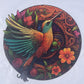 Conundrum House - Round Wooden Puzzle - Hummingbird. Completed puzzle showing detailed and intricate artwork and coloring, and some of the intricate nature of the puzzle pieces themselves.