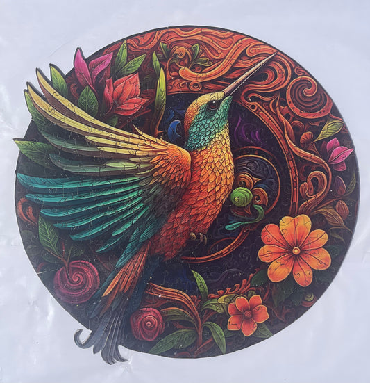 Conundrum House - Round Wooden Puzzle - Hummingbird. Completed puzzle showing detailed and intricate artwork and coloring, and some of the intricate nature of the puzzle pieces themselves.