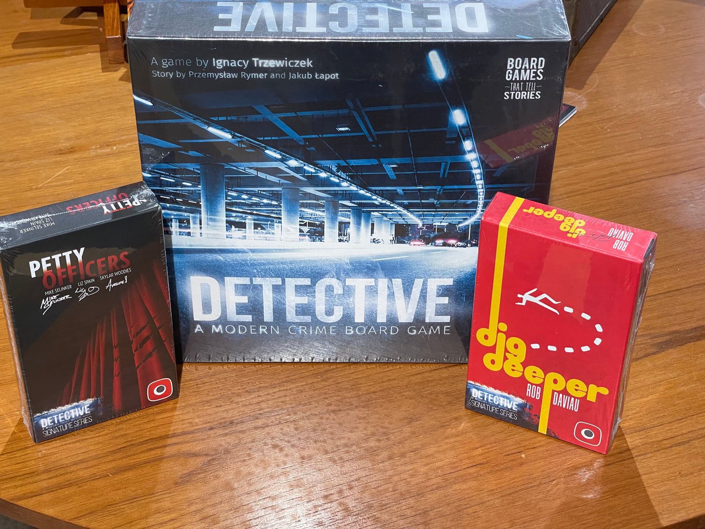 The main game and the two expansion sets, Dig Deeper and Petty Officers - Expansion sets for Detective: A Modern Crime Board Game.  These are expansions to the legendary criminal board game Detective by Ignacy Trzewiczek. For sale at Conundrum House and online at https://conundrum.house